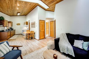 A spacious living area with a high ceiling, wooden flooring, a dining table with chairs, a sofa, and a coffee table. - Hike, Paddle & Relax: Cabin By Cle Elum Lake (Ronald)