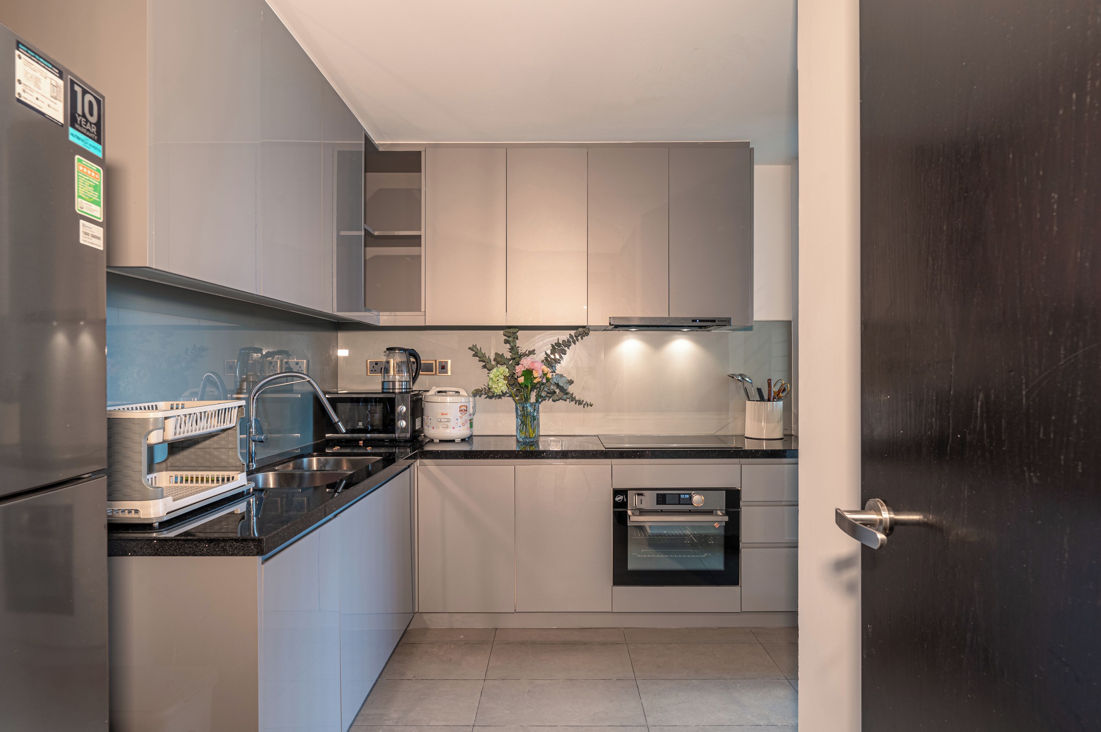 Una cocina moderna con electrodomésticos de acero inoxidable, horno empotrado y una isla grande con fregadero.