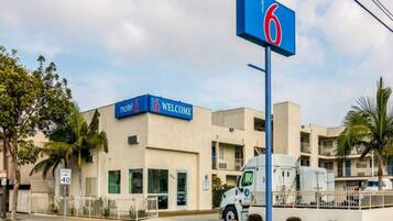 A motel with a '6' sign, a speed limit sign, and a welcoming sign.