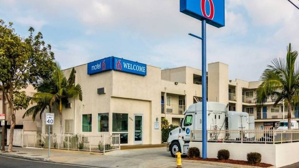 A motel with a '6' sign, a speed limit sign, and a welcoming sign. - 1 King Bed | Non-Smoking, Micfridge (Bell Gardens)