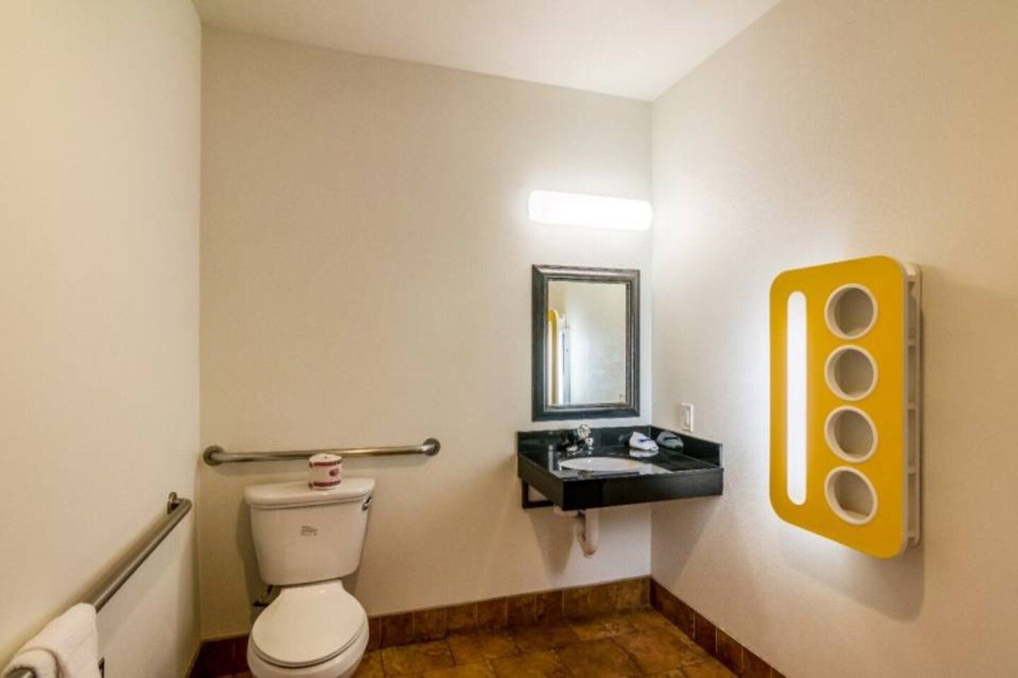 A small bathroom with a toilet, a sink, and a mirror.