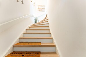 Un escalier avec des marches en bois et un paillasson au bas.