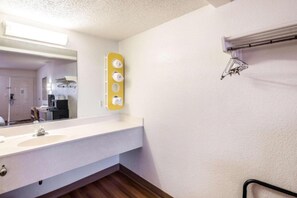 Un bagno d'hotel con uno specchio grande, un lavandino e un porta asciugamani.
