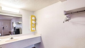 Un baño de hotel con un espejo grande, un lavabo y un perchero para toallas.