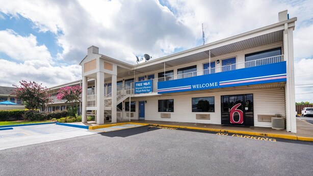Un edificio con fachada azul y blanca, un cartel que ofrece Wi-Fi gratuito y el número 6 que indica la entrada.