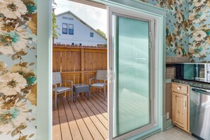 A sliding glass door leading to a patio with a wooden deck, two chairs, and a table. - 'Feels Like Home' Quiet Home Near Wartrace Shops (Wartrace)