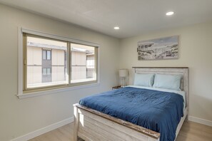 A bedroom with a bed, a window, a nightstand, and a painting on the wall. - 1 Mi to Beach! Walkable Extended Base in Monterey (Monterey)