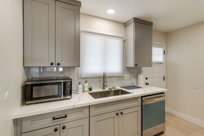 A kitchen with a built-in microwave, a sink, and cabinets.