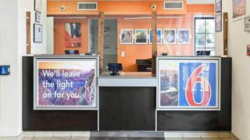 A reception desk with a sign that reads 'We'll leave the light on for you.'