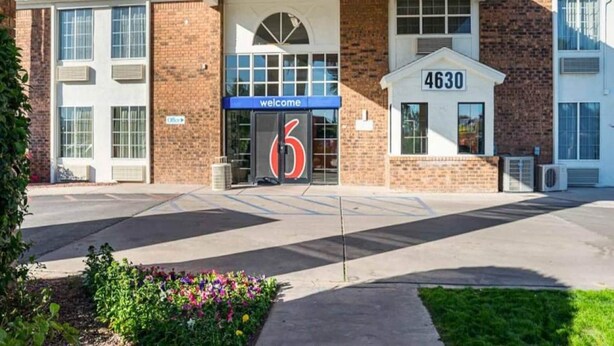 Ein Hotel Eingang mit einem ‚Welcome‘ Schild, einer Nummer ‚4630‘ und einem Parkplatz.
