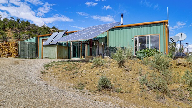 Uma casa moderna com painéis solares, uma janela grande e uma antena parabólica.