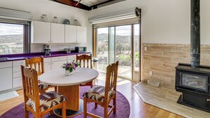 Uma cozinha moderna com área de refeições, uma janela grande e uma lareira a lenha.