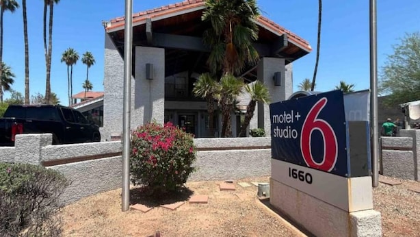 A motel with a red roof and a sign indicating it is number 6. - 1 King Bed | Non-Smoking, Micfridge (Tempe)
