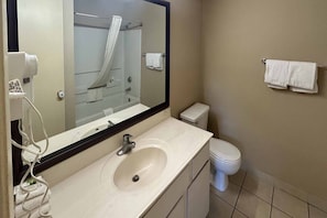 Un baño con lavabo, espejo, inodoro y toallero.
