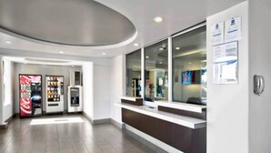 A reception area with a counter, a Coca-Cola vending machine, and an ice dispenser. - MS6 Victorville|1 King Bed|NS (VICTORVILLE)
