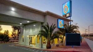 A 6 studio hotel with a parking lot and a sign indicating free Wi-Fi. - MS6 Victorville|1 King Bed|NS (VICTORVILLE)