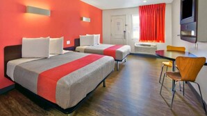 Een hotelkamer met twee bedden, een bureau en een stoel.