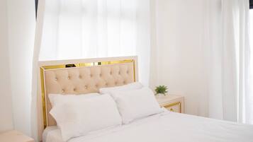 Una camera da letto con un letto, un comodino, una ventola a soffitto e una finestra con tende.