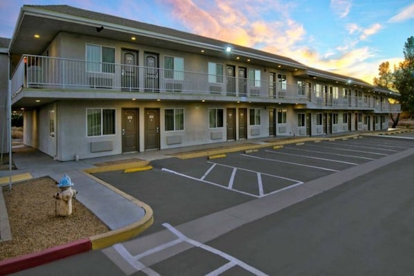 Um motel com estacionamento e hidrante.
