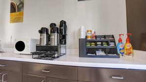 A hotel room counter with a coffee maker, a water dispenser, and a small refrigerator. - 1 QUEEN BED | NON-SMOKING (Benson)