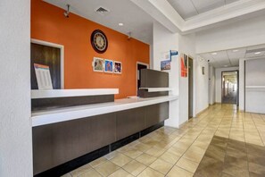 A reception area with a counter, a clock, and a corridor leading to other rooms.