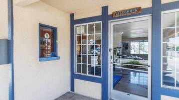 A building entrance with a blue door and a welcome sign.
