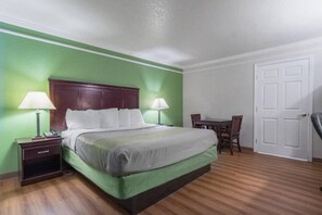 A hotel room with a bed, bedside tables, a desk, and a chair. - Comfy King Bed|Pool|Free Parking (Kingsburg)