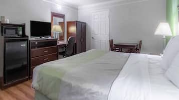 Une chambre d’hôtel comprenant un lit, un bureau avec une chaise, une télévision, une armoire et une porte.