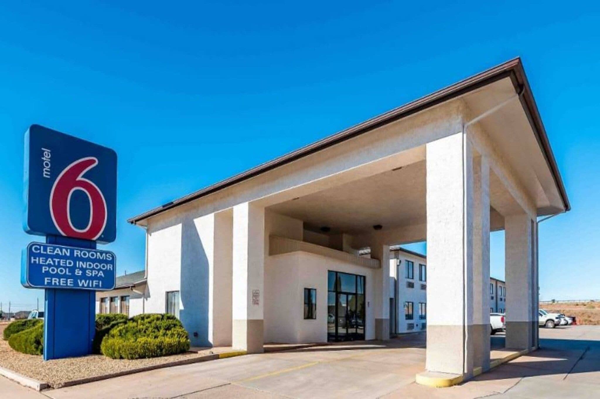 Ein Motel mit einem gut sichtbaren Schild, das Annehmlichkeiten wie saubere Zimmer, einen beheizten Innenpool und kostenloses WLAN anzeigt.