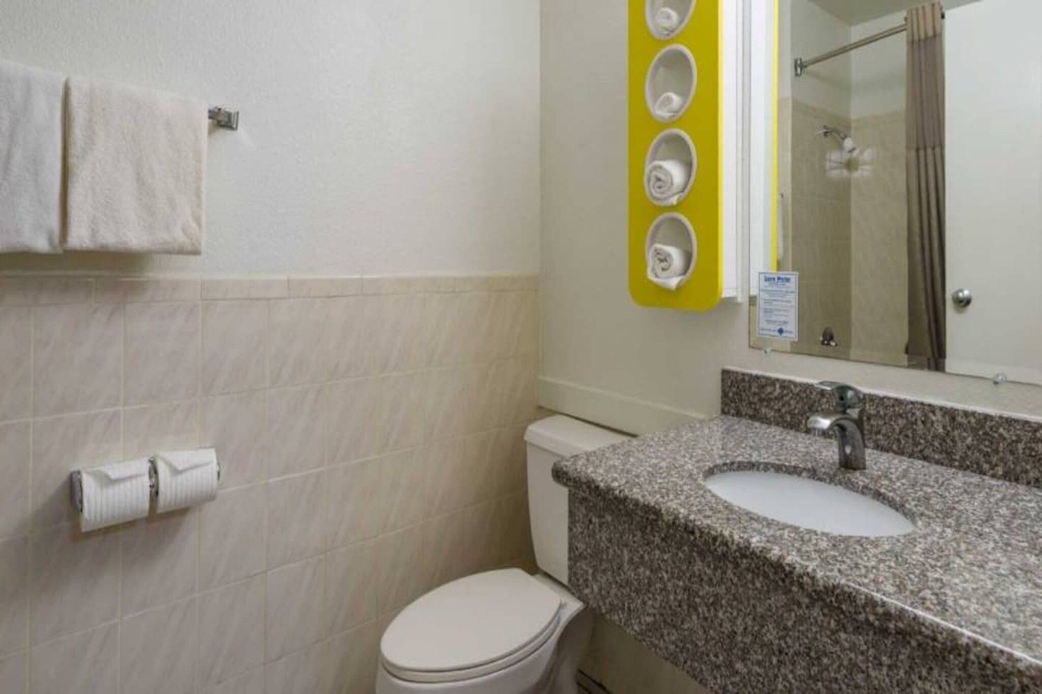 Un baño con inodoro, lavamanos y toallero.