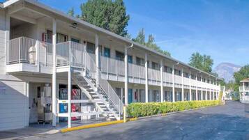 A motel with a central staircase, multiple balconies, and a parking lot.