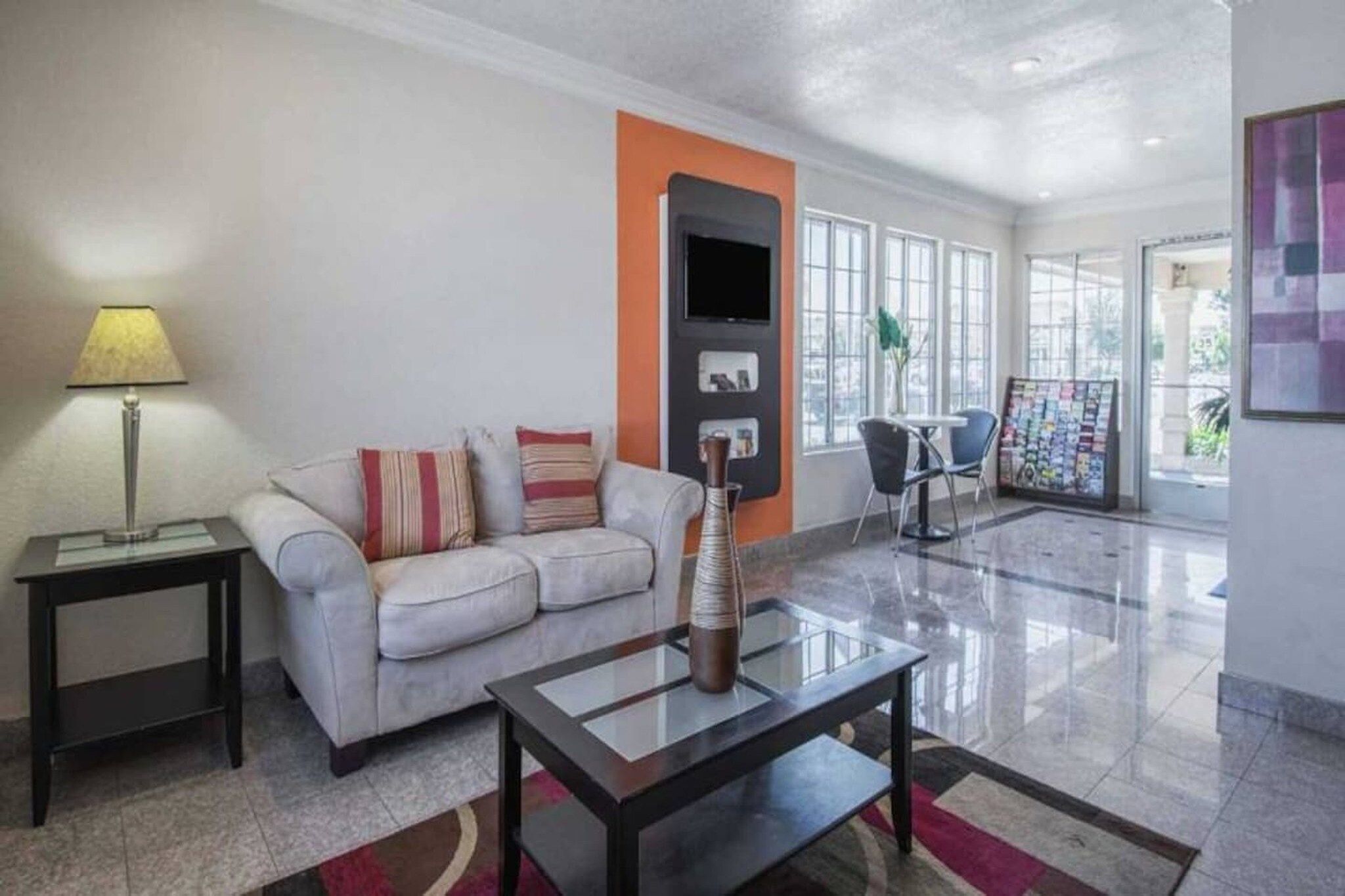 A modern living room with a sofa, a coffee table, a lamp, and a TV.