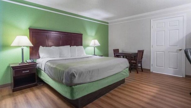 A hotel room with a bed, bedside tables, a desk, and a chair. - 1 King Bed | Mobility Accessible Tub, Nsmk (Kingsburg)