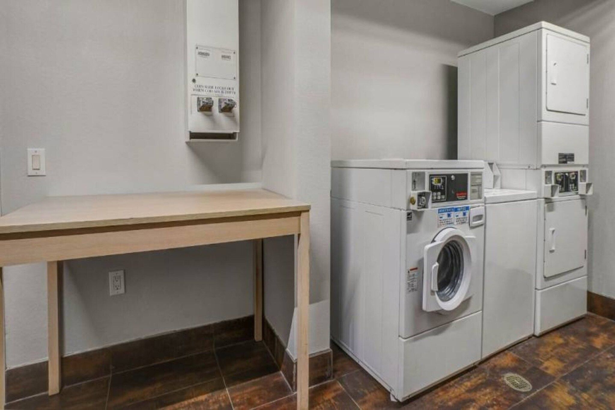 A laundry room with a washing machine, dryer, and a table.