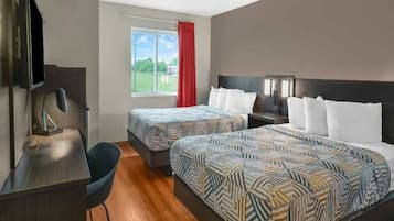 Une chambre d’hôtel avec deux lits, un bureau, une chaise, une télévision et une fenêtre donnant sur l’extérieur.