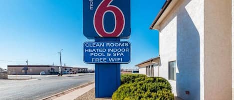Motel Schild mit Annehmlichkeiten wie saubere Zimmer, beheiztem Hallenbad und Spa sowie kostenlosem WLAN.