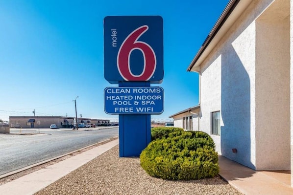 A motel sign with amenities including clean rooms, heated indoor pool & spa, and free WiFi.