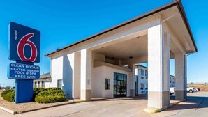 Een motel met een duidelijk bord waarop voorzieningen staan zoals schone kamers, een verwarmd binnenzwembad en gratis WiFi.
