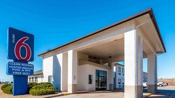 A motel with a clear sign indicating amenities such as clean rooms, heated indoor pool, and free WiFi.