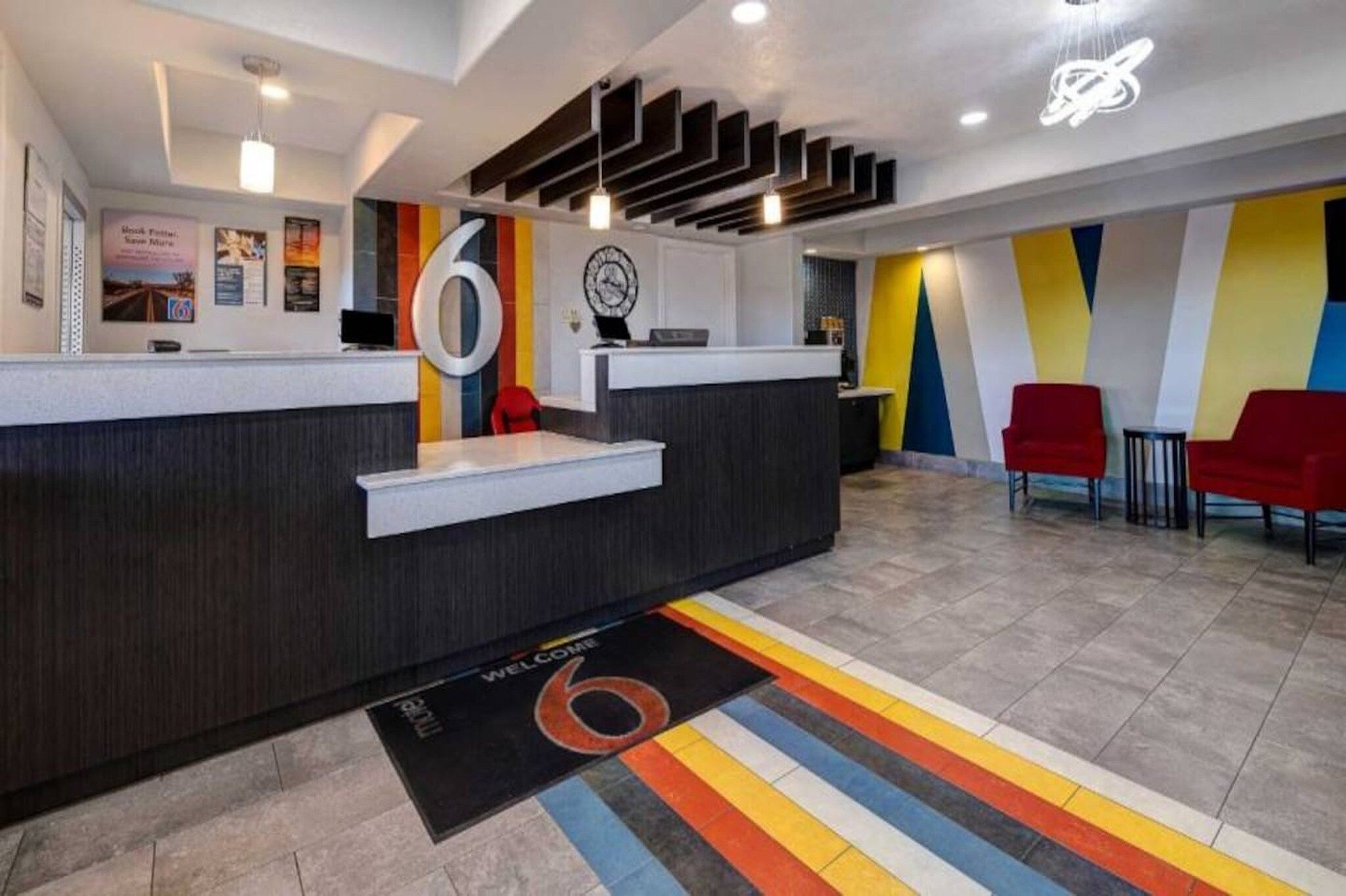 A reception area with a modern design, including a reception desk, a clock, and a colorful wall.