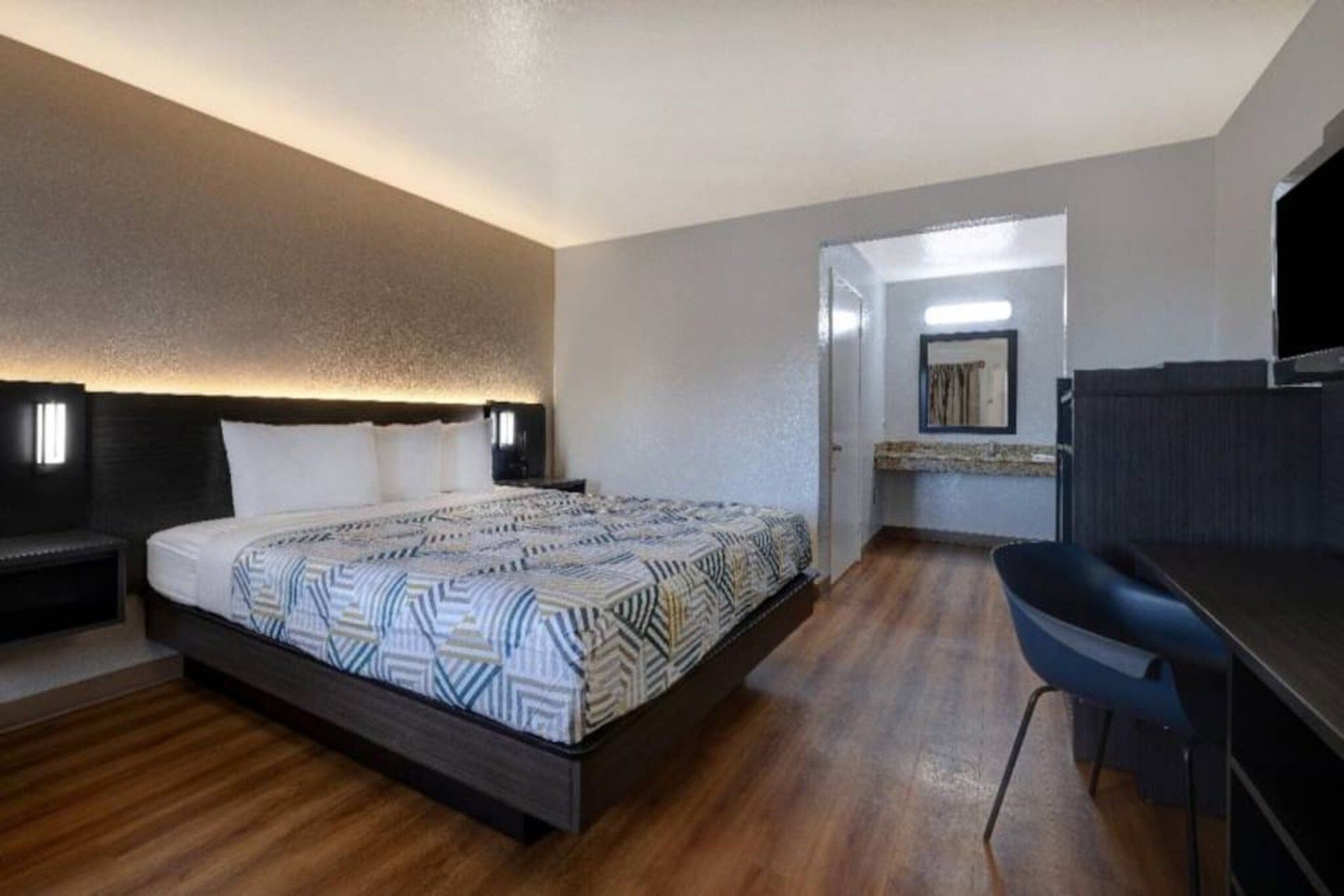 Una habitación de hotel con cama, escritorio y baño.