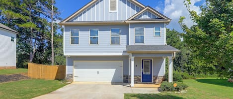 A two-story residential house with a garage, a front porch, and a driveway.