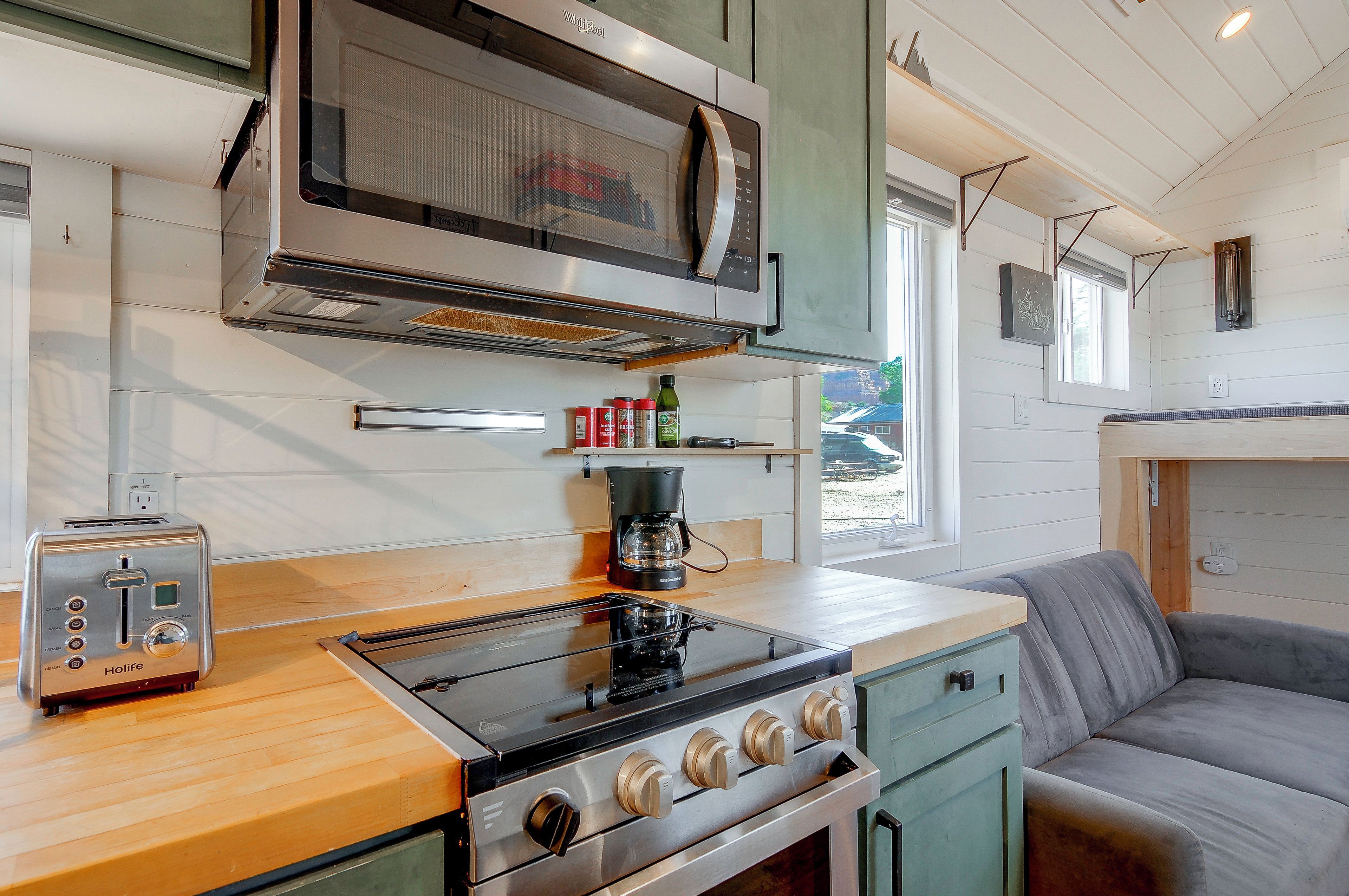 A compact kitchen with a toaster, a stove, and a microwave.
