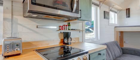 Una cocina compacta equipada con tostadora, estufa y microondas.