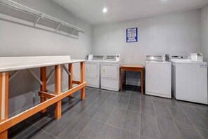A laundry room with a table, cabinets, and washing machines.