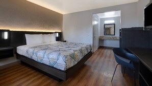 Una habitación de hotel con cama, escritorio y baño.