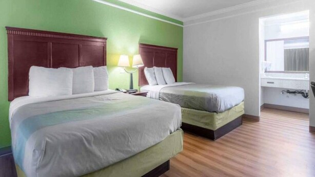A hotel room with two beds, a nightstand, a lamp, and a window. - Elegant 2 Queen Beds Room|Free Wifi (Kingsburg)
