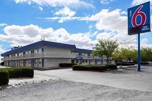 A motel with a large sign indicating '6 rooms, one person per room.'