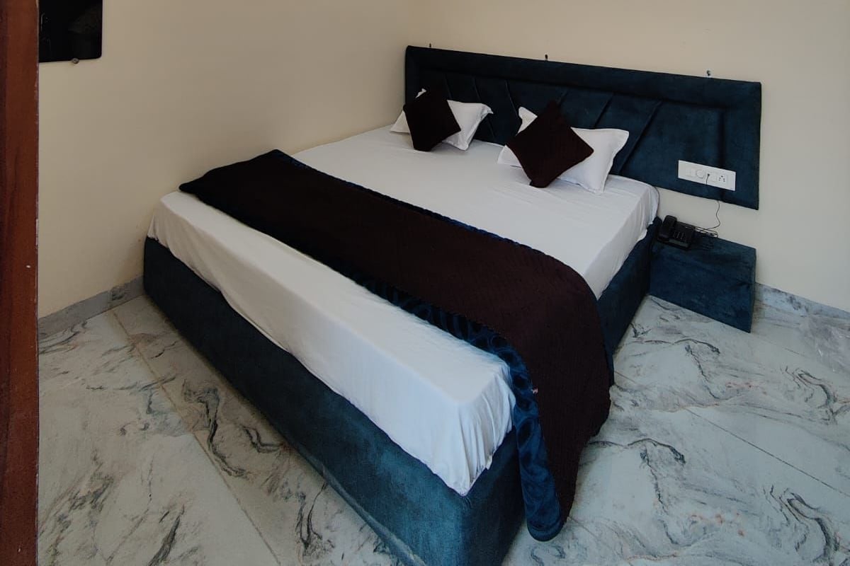 Quarto com cama, ventilador de teto, iluminação embutida e piso de mármore.