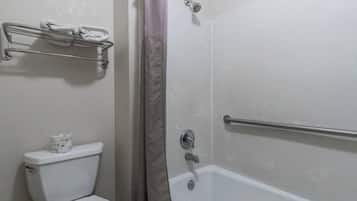 Een badkamer met toilet, douche met een greep en een handdoekhouder.